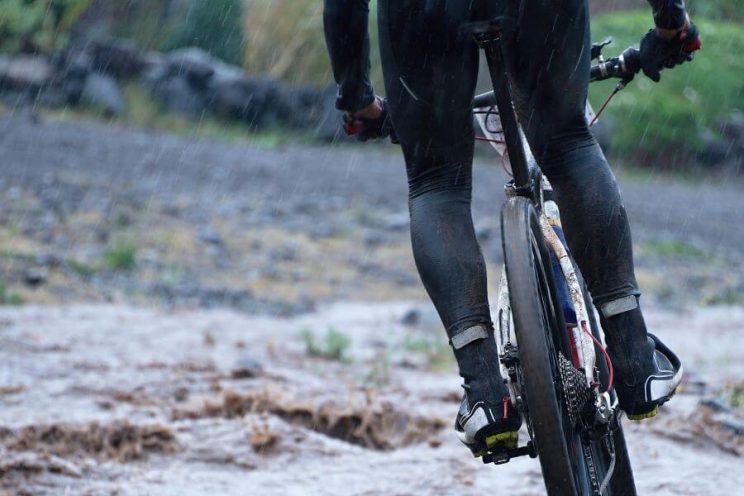 Vue arrière d'un cycliste en vélo de montagne sous la pluie