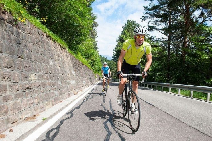 Couple de cycliste homme et femme avec vélo de route en été sur route sinueuse